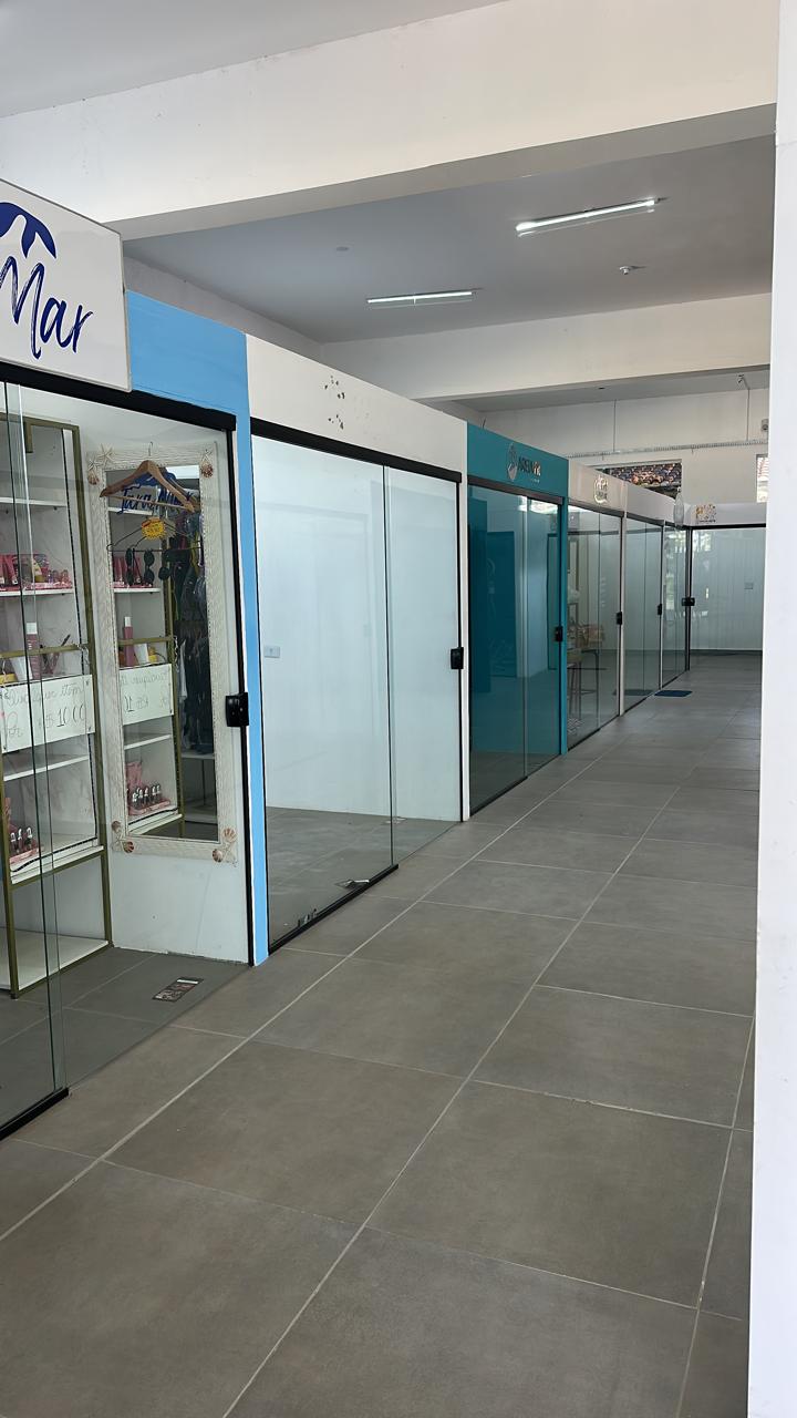 Corredor interno do shopping com boxes comerciais e portas de vidro