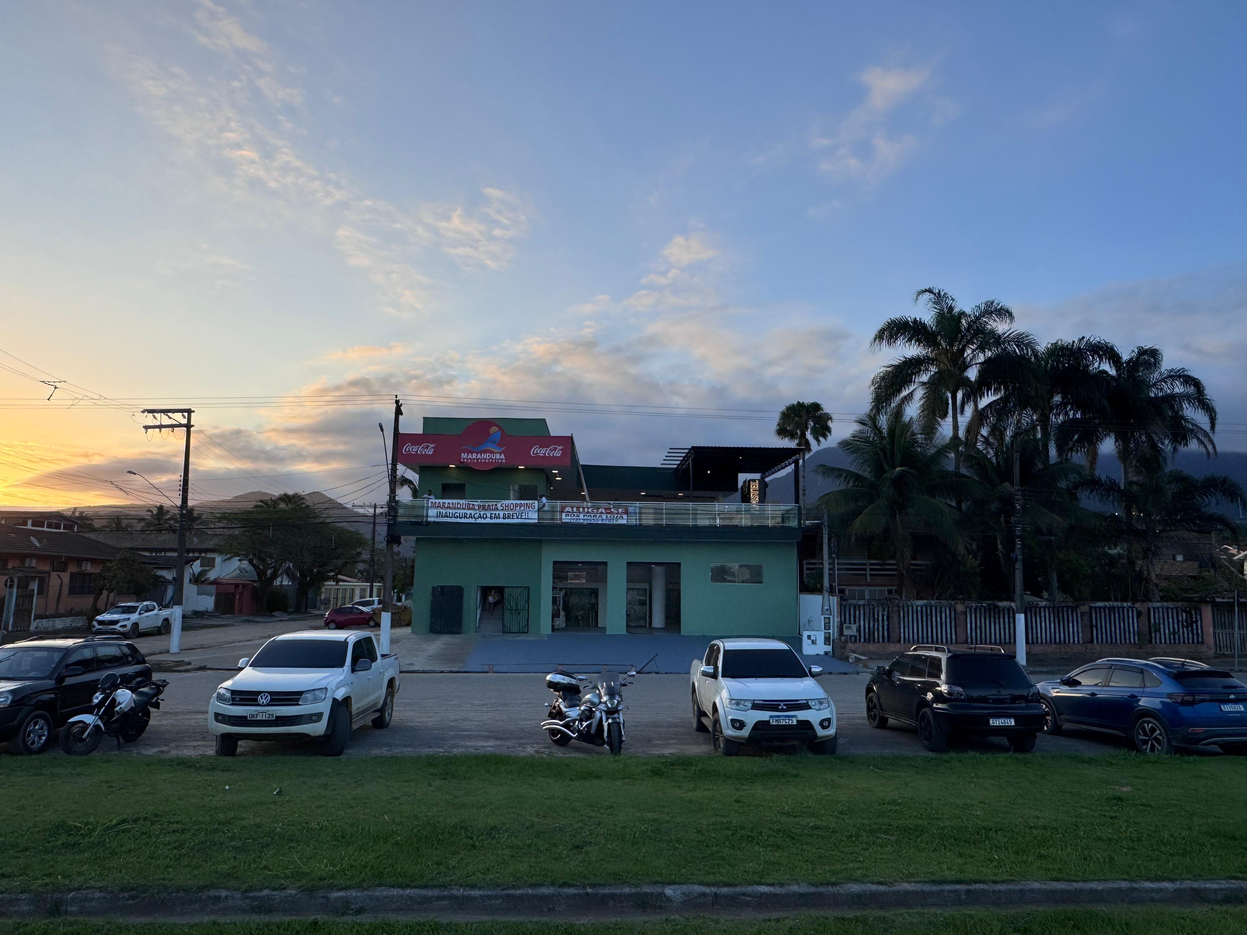 Fachada do Maranduba Praia Shopping ao entardecer, com coqueiros ao lado